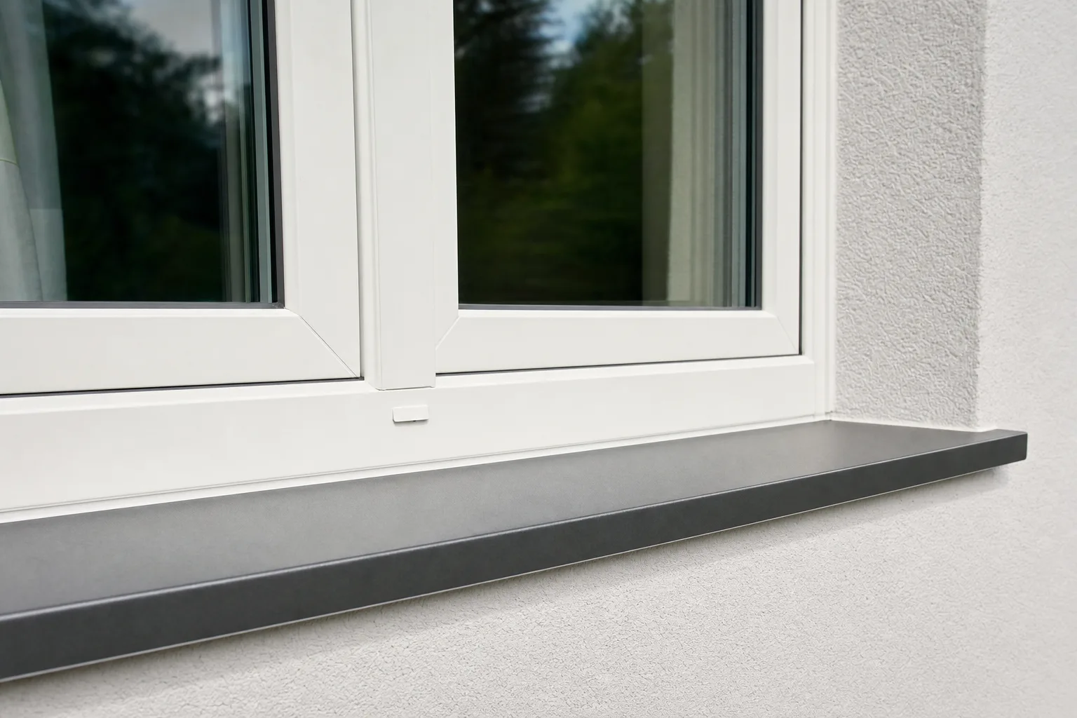 Modernes Kunststofffenster mit weißem Rahmen in einer verputzten Hausfassade, saubere Anschlussdetails.