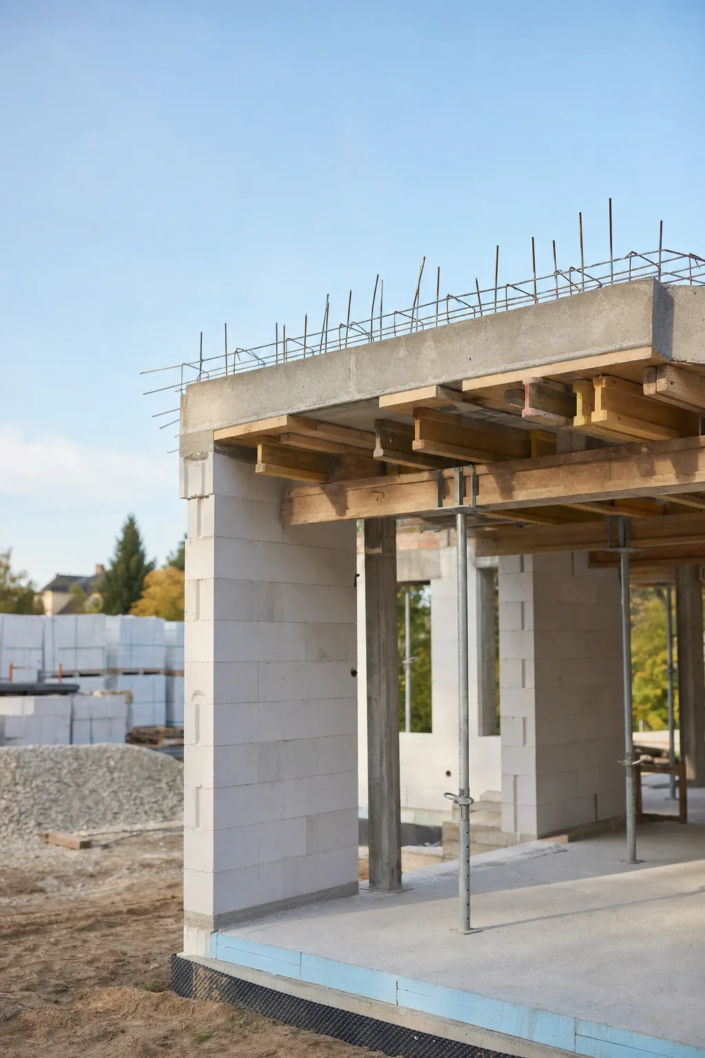 Rohbau eines Einfamilienhauses aus Kalksandstein-Mauerwerk mit frisch betonierter Geschossdecke.